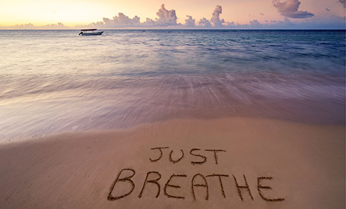 just breathe written in beach sand